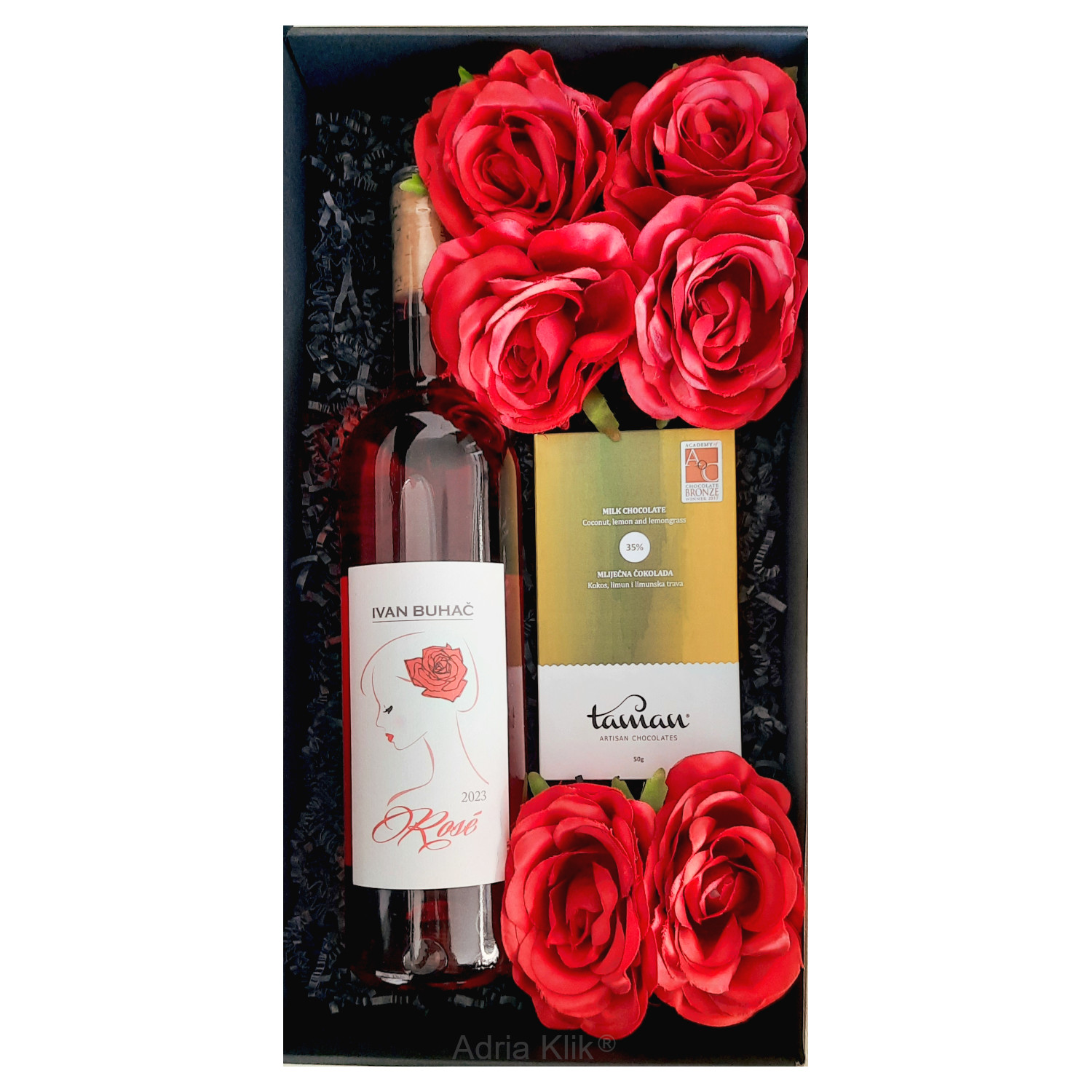 Vrhunski i unikatni Premium poklon paket Poklon paket sadrži: Taman Atisan Chocolates Čokolada Mlij. 35% s kokosom, limunom i limunskom travom 50g. Crvene Ruže od svile x 6 kom Poluslatki Rose 0,75l Buhač Mat Crna kutija s prozorom i dekoracijom Poluslatki Rose naglašenih voćnih aroma crvenog voća kao što su maline, jagode. Buhač Ilok ZOI Naruči dostavu poklona online vino, Artisan Taman čokolada i ruže Wine, Artisan Chocolates & Roses